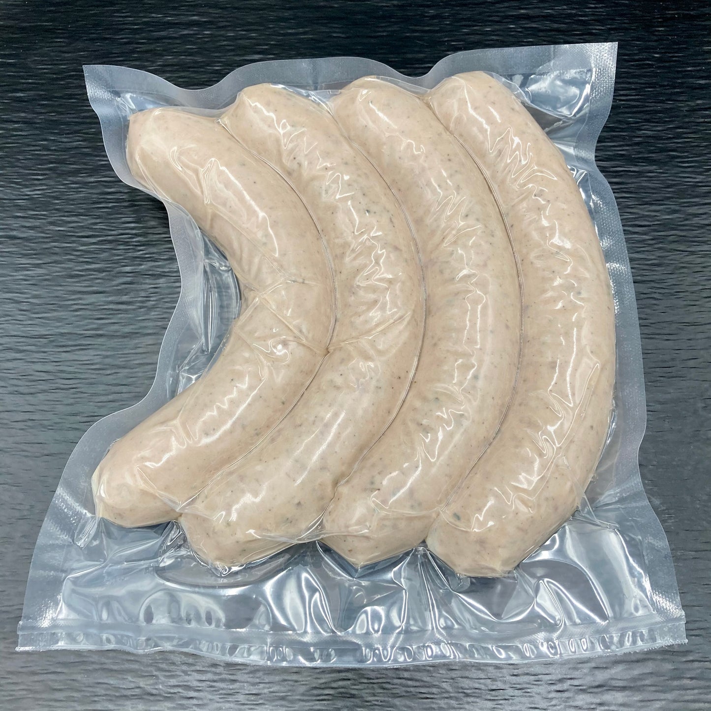 Vier Rindsbratwürste vakuumiert verpackt