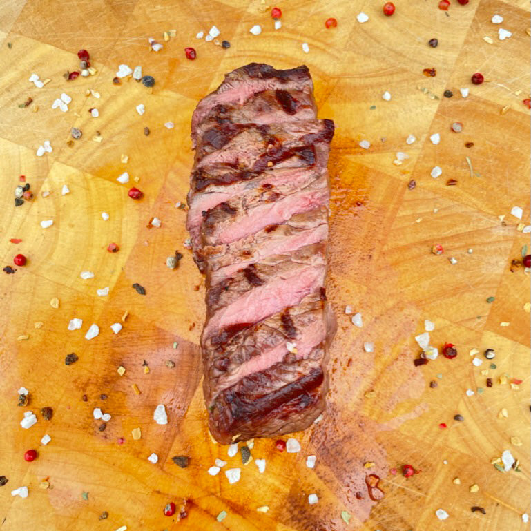 Roastbeef geschnitten auf Holzbrett mit Gewürzen