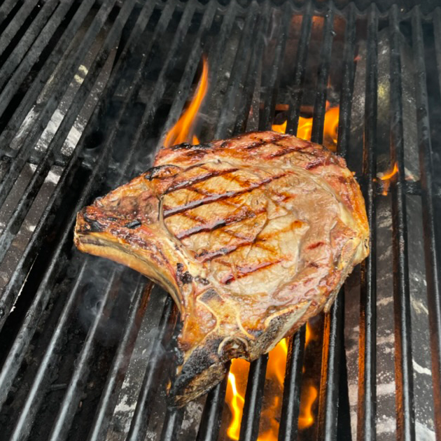 Rib Eye Bone In auf Grillfest mit Feuer